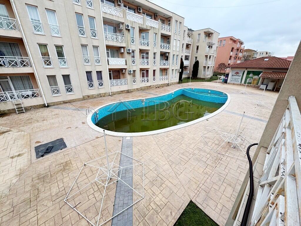 Balcony overlooking a swimming pool in a modern apartment complex at Sunny Beach.
