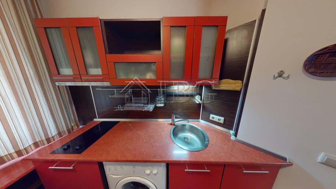 Modern kitchen with red cabinets and built-in appliances in Kosharitsa complex.