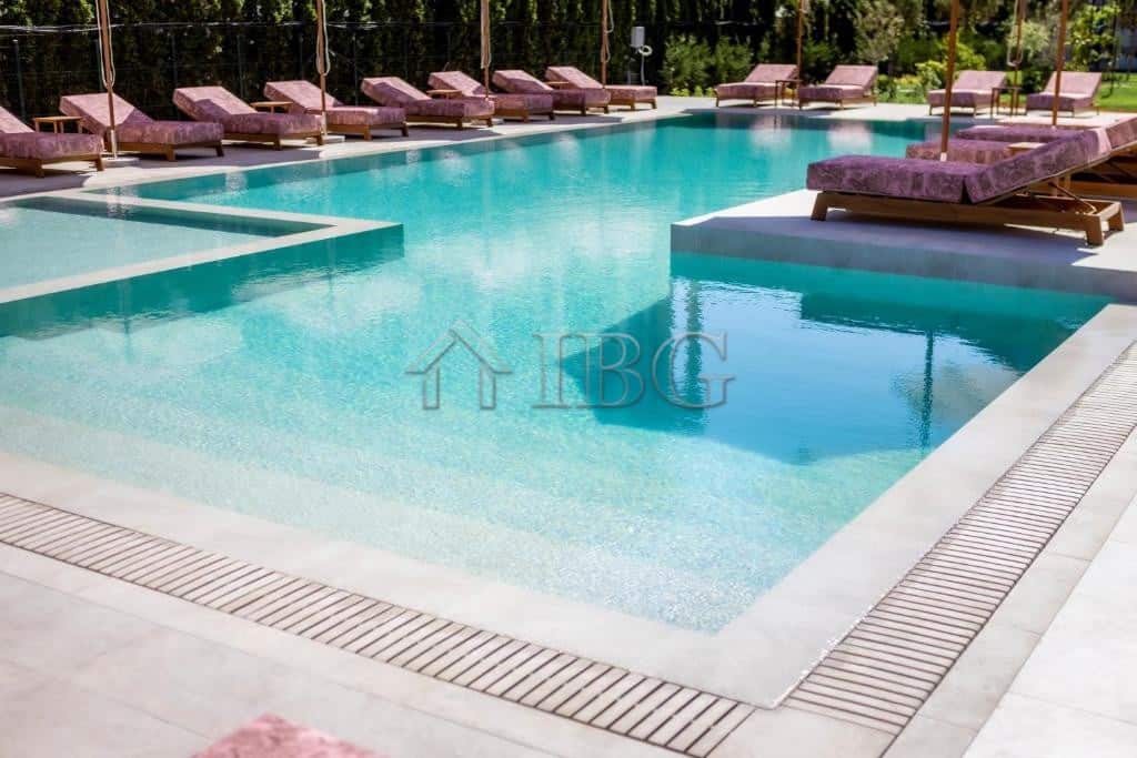 Swimming pool with lounge chairs at J’adore Secret Garden residential complex in Sunny Beach.