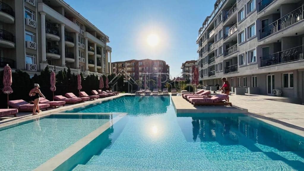 View of a luxurious apartment complex with a swimming pool in Sunny Beach, Bulgaria.