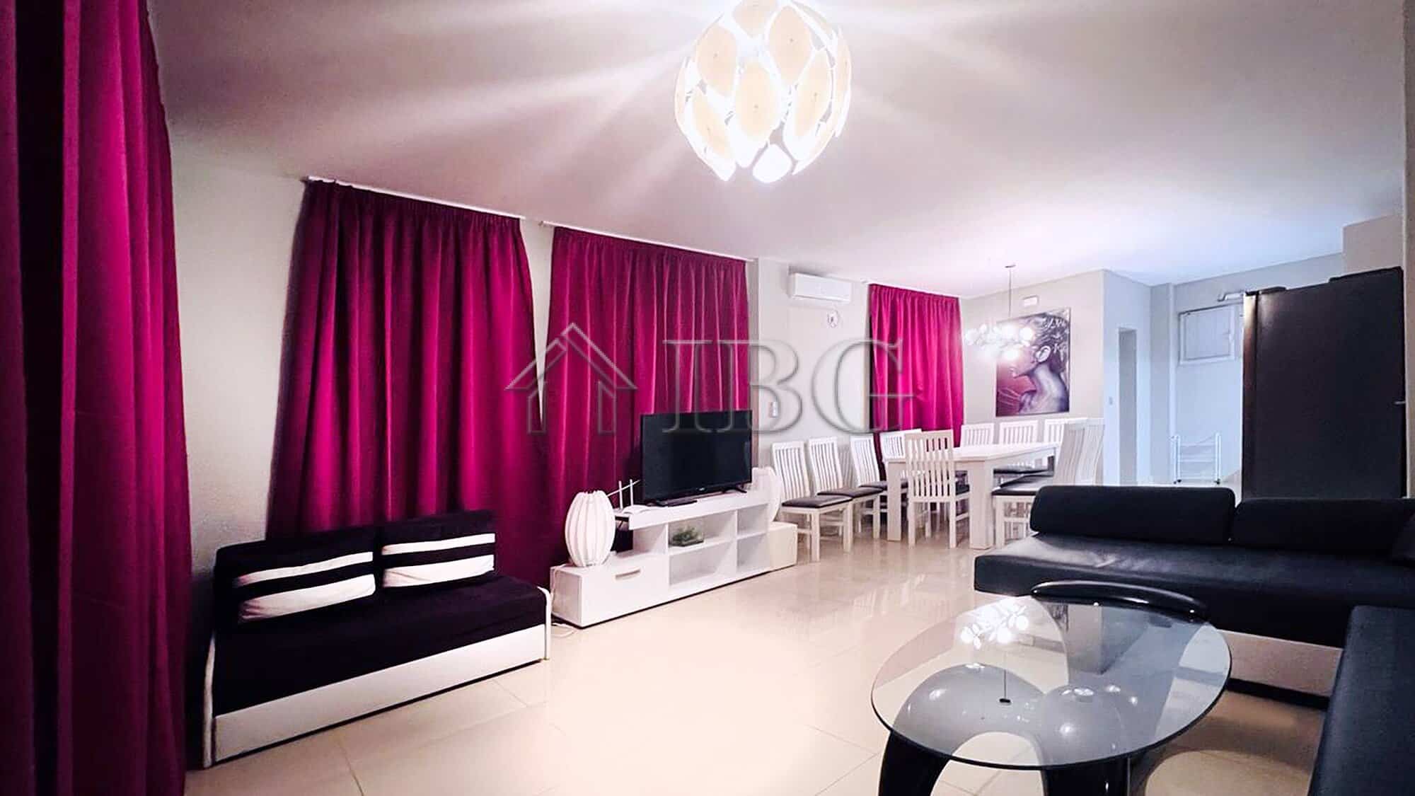 Elegant living room with vibrant pink curtains and modern furniture in Villa Sorrento.
