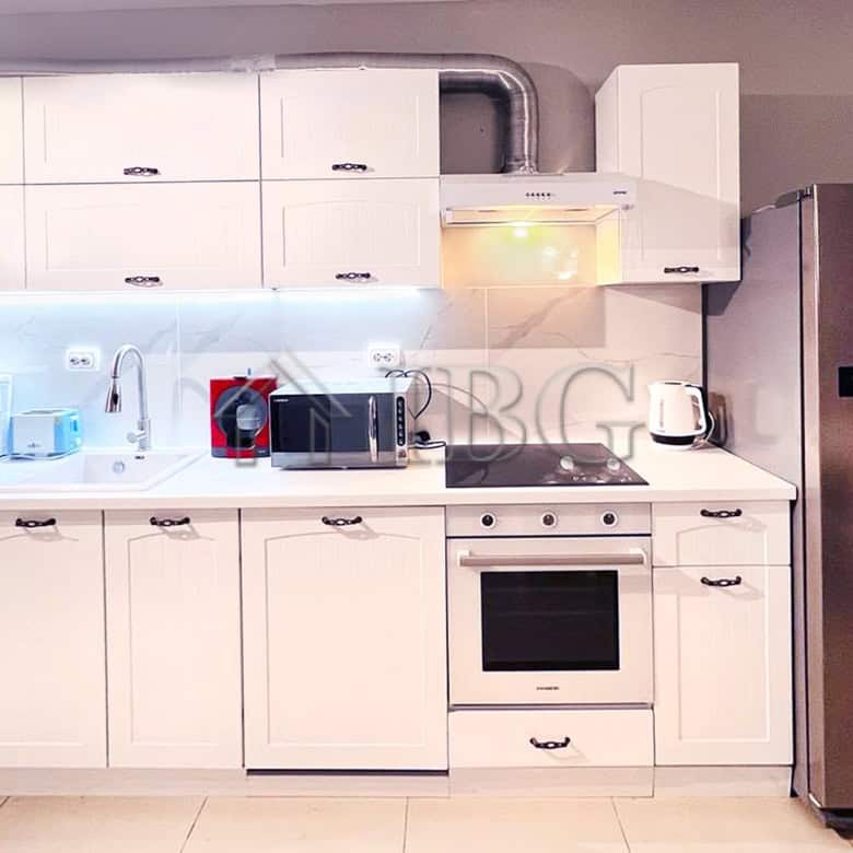 Bright, clean kitchen featuring modern white cabinets, appliances, and ample storage space.