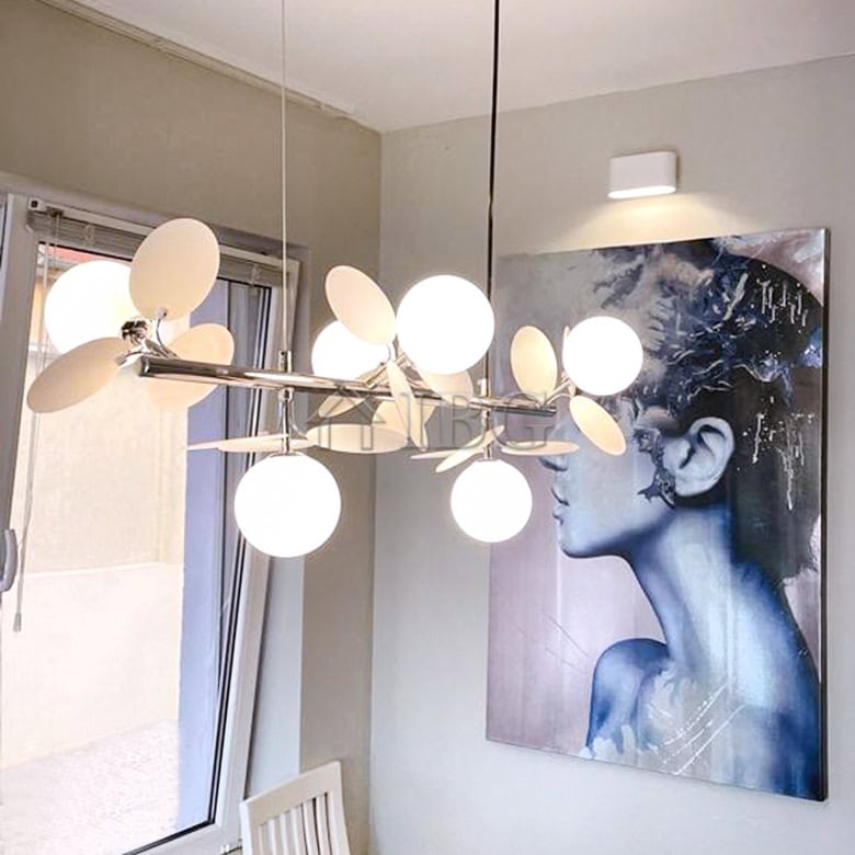 Chandelier with multiple white globes hanging in a contemporary dining area.