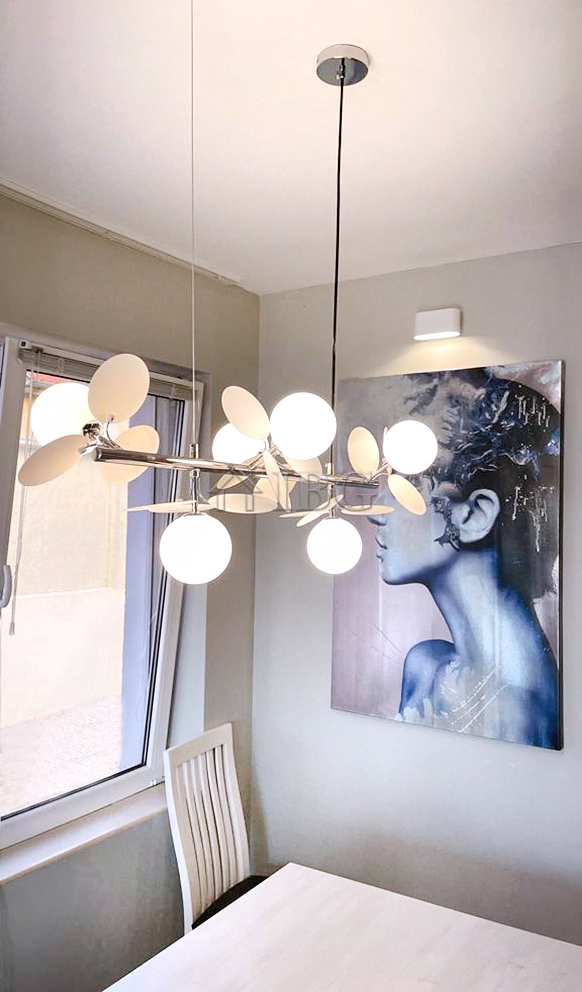 Chandelier with multiple white globes hanging in a contemporary dining area.