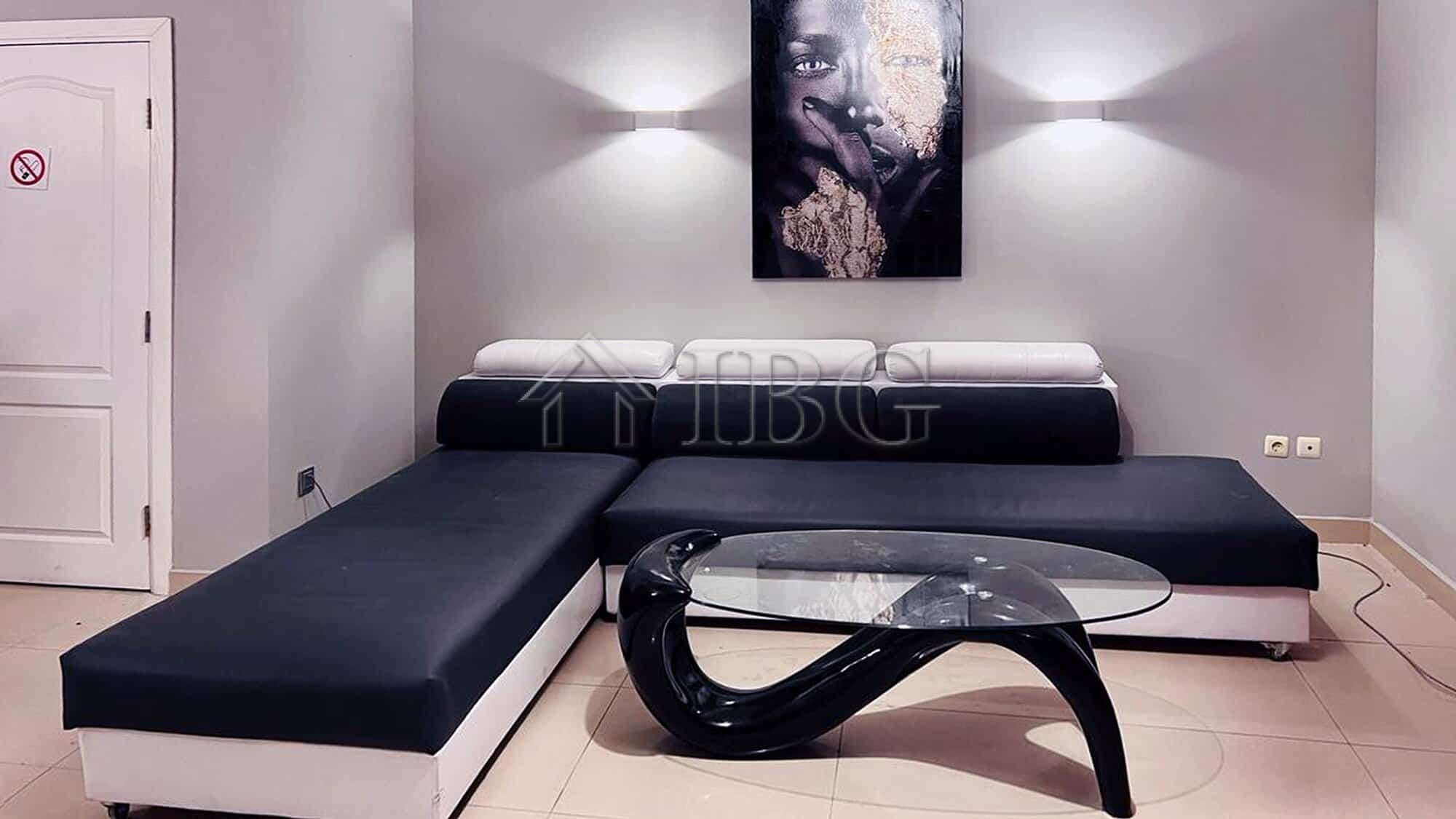 Stylish living space featuring black and white furniture, modern art, and ambient lighting for a lux.