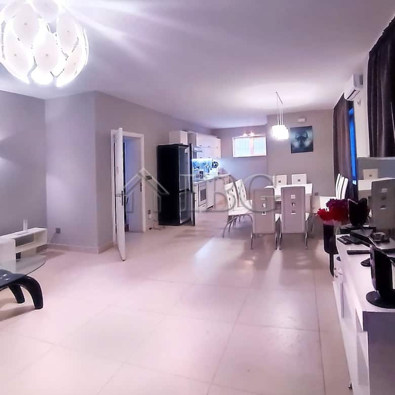Spacious living area featuring contemporary decor, a dining table, and entertainment setup.