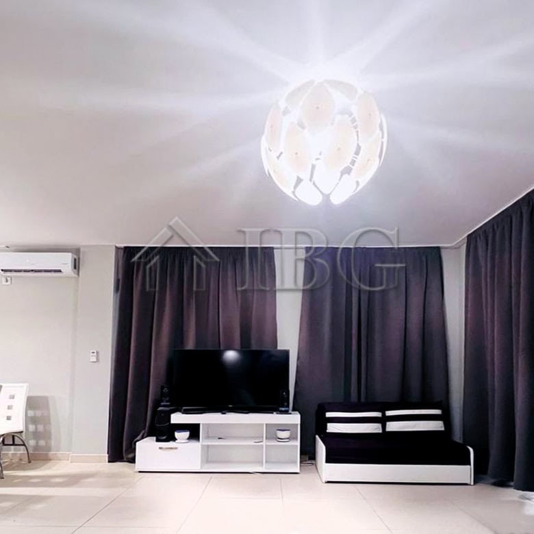 Modern living room with sea view, stylish furniture, and dark curtains.