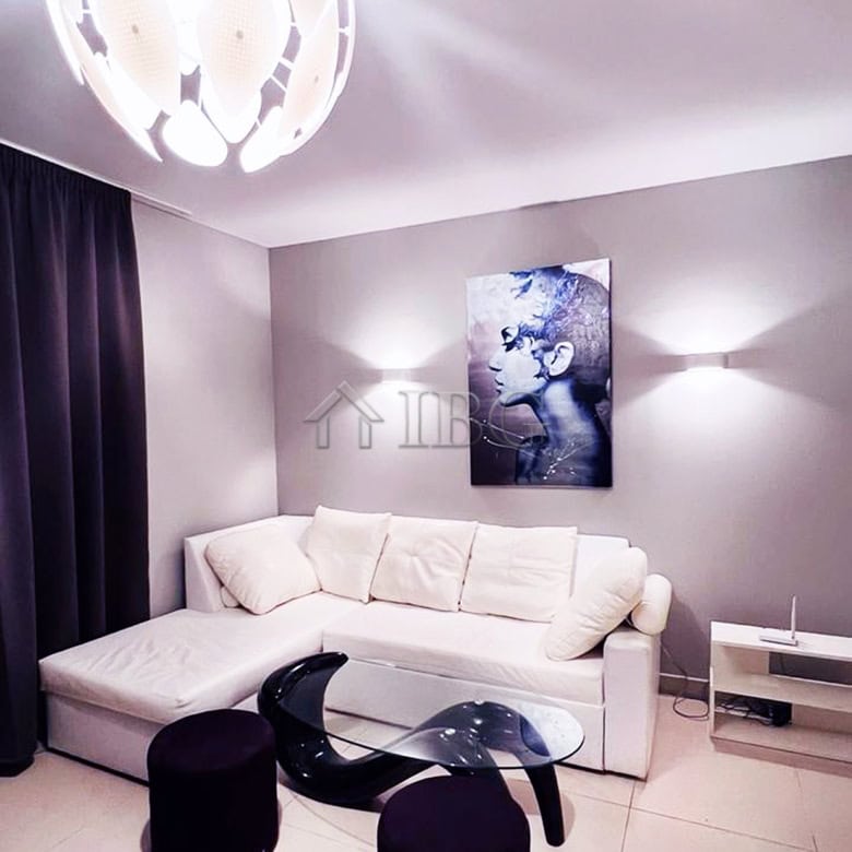 Elegant living room featuring a white sofa, contemporary art, and stylish lighting fixtures. Perfect.