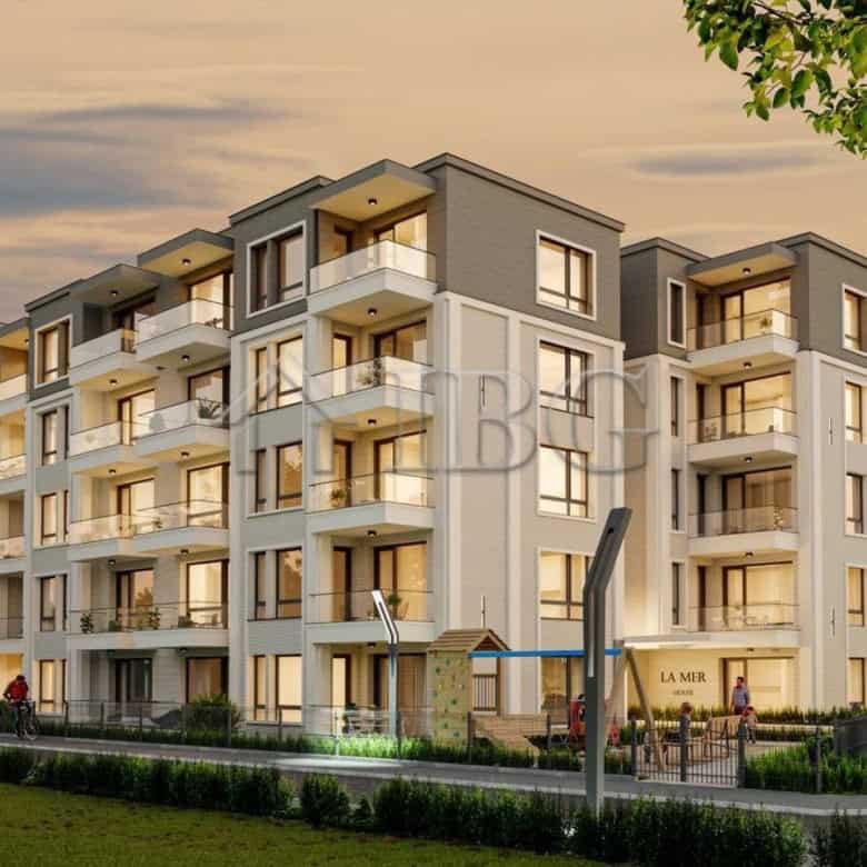 Contemporary apartment complex at La Mer House in Ravda with balconies and lush surroundings.