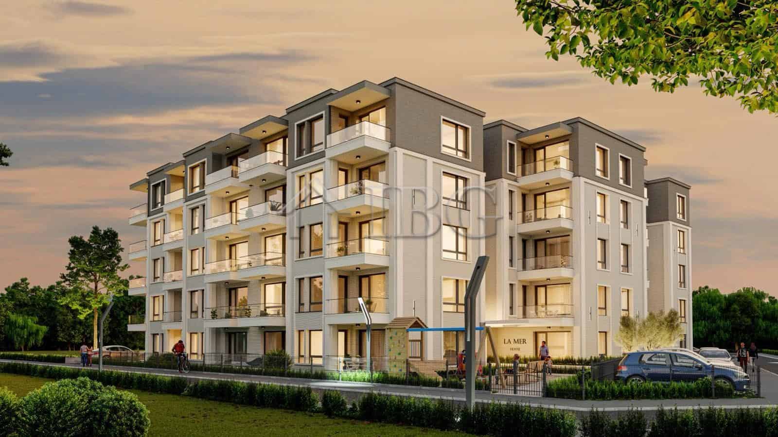 Contemporary apartment complex at La Mer House in Ravda with balconies and lush surroundings.