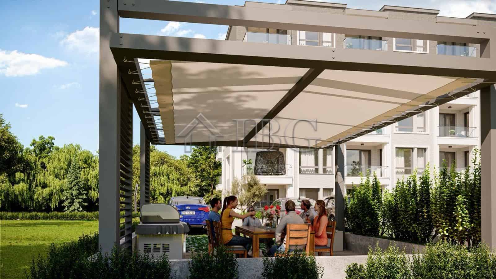 Outdoor dining space with a large canopy at La Mer House, a new residential development in Ravda, Bu.