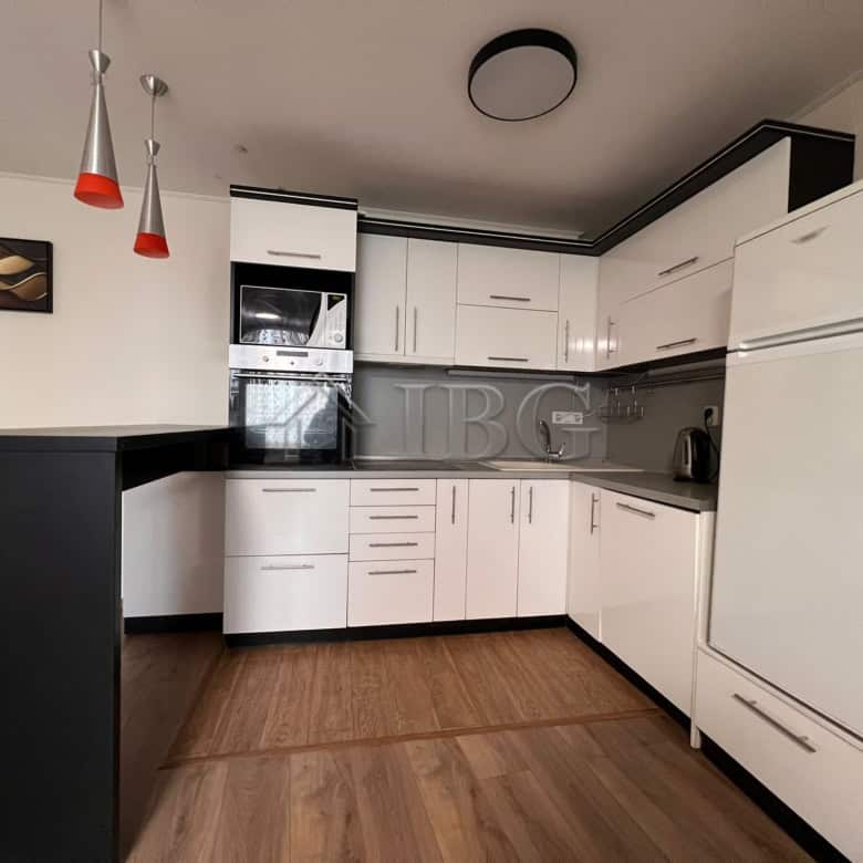 Bright and spacious kitchen featuring white cabinets, black countertops, and modern appliances in a.