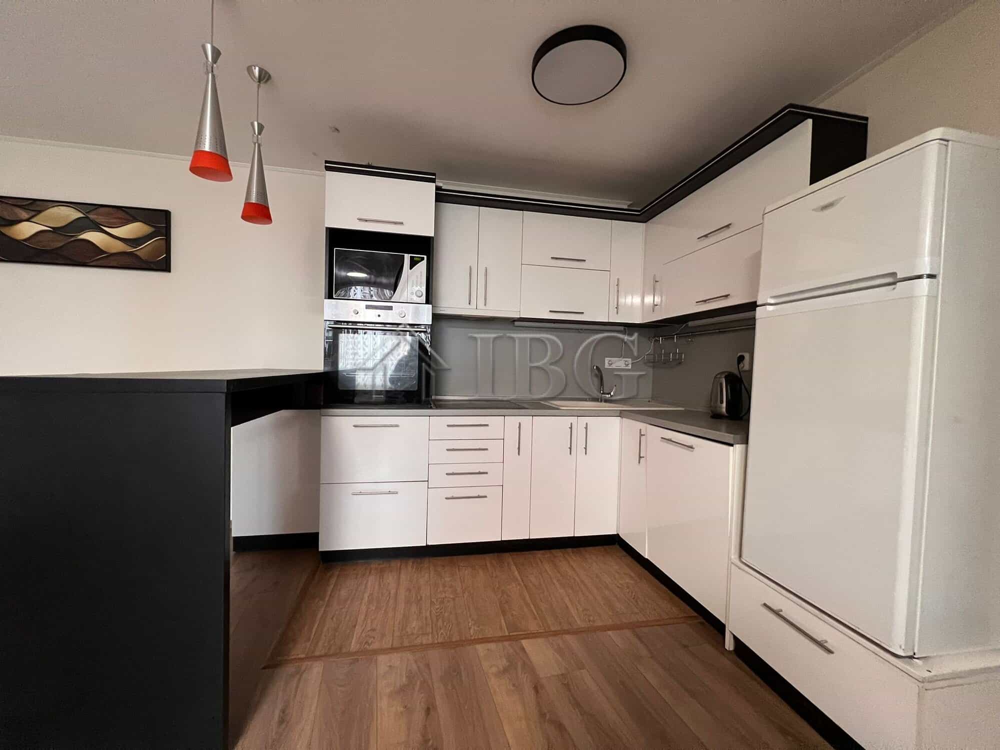Bright and spacious kitchen featuring white cabinets, black countertops, and modern appliances in a.
