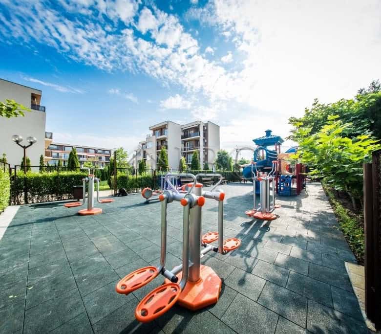 Outdoor gym equipment in a sunny, landscaped setting at Nessebar Fort Club, Sunny Beach.