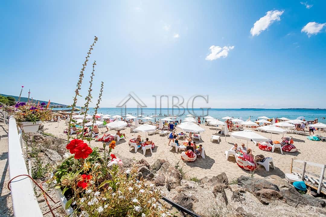 Beachfront apartment for sale in Sveti Vlas Beautiful beach scene with sun loungers and umbrellas at Premier Fort Beach, Sveti Vlas.