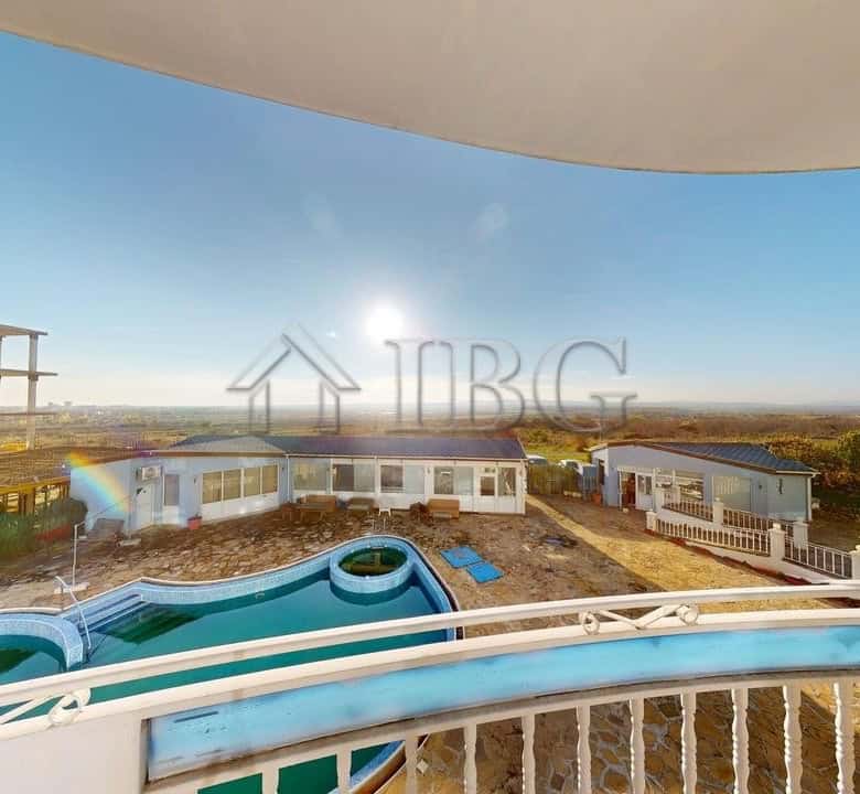 Modern balcony overlooking Rio apartments, pool, and surrounding cityscape with clear blue sky.