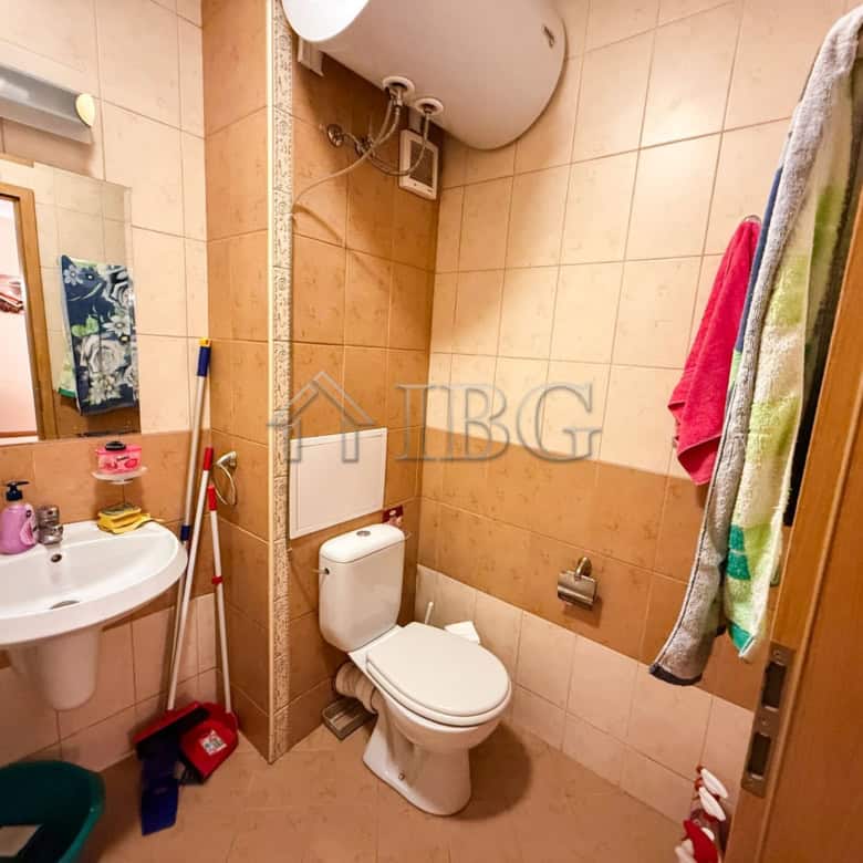 Bright bathroom with toilet, sink, and colorful towels in Sunny Beach.