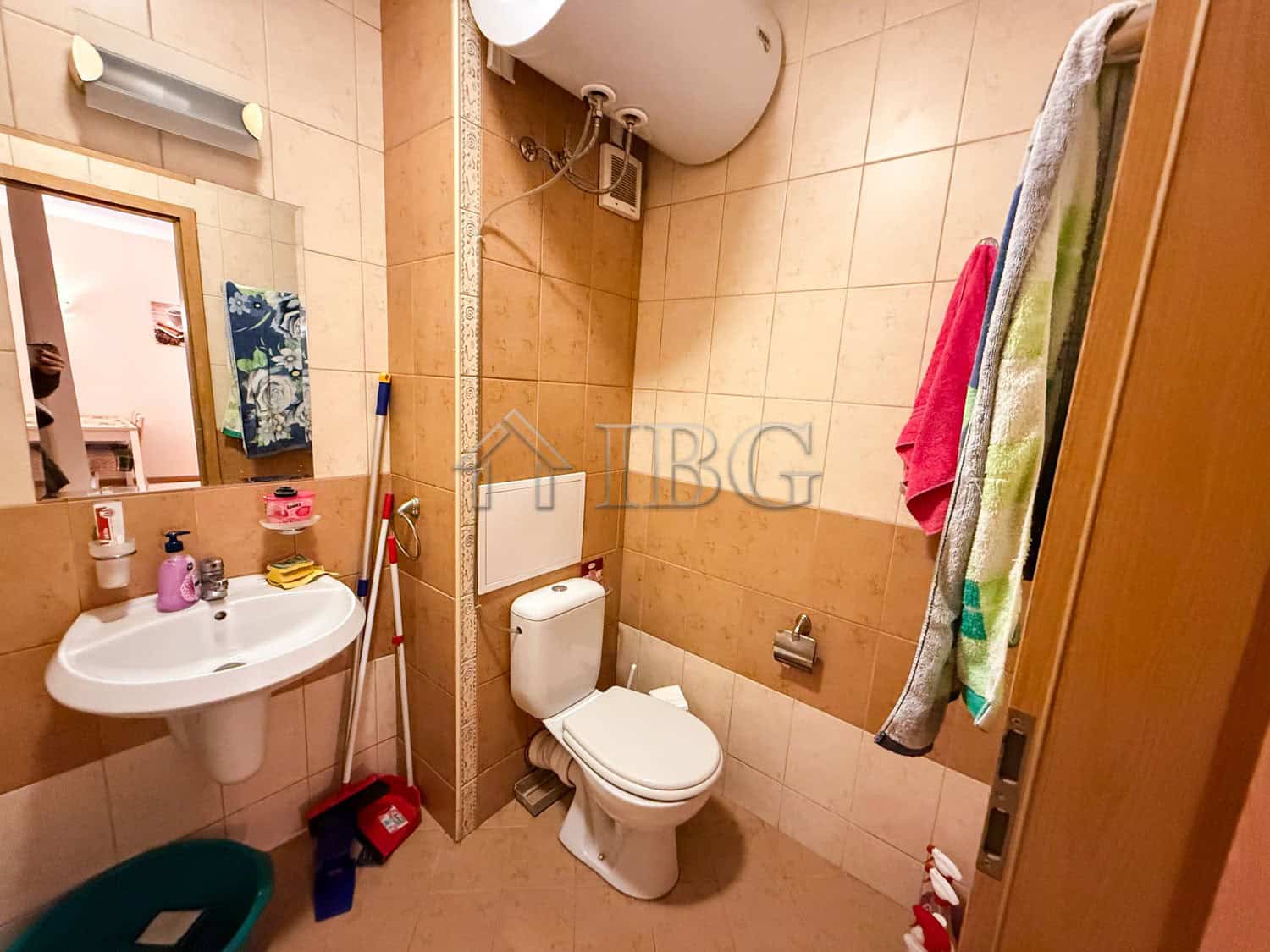 Bright bathroom with toilet, sink, and colorful towels in Sunny Beach.
