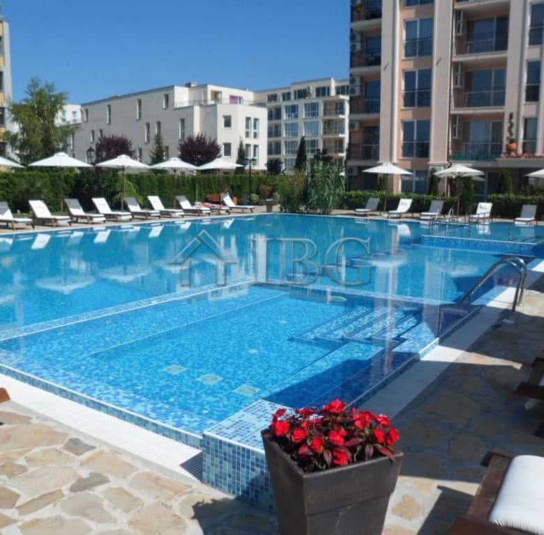 Pool area with sun loungers and umbrellas at a 2-bedroom apartment in Sunny Beach.