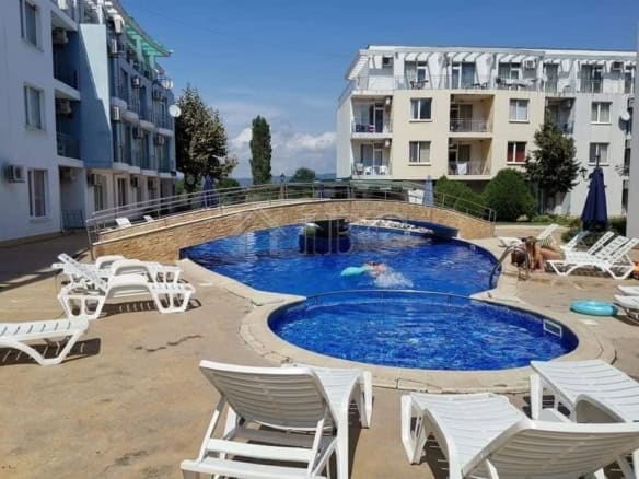 Bright outdoor pool area at Sunny Day 3, Sunny Beach with lounge chairs and scenic surroundings.