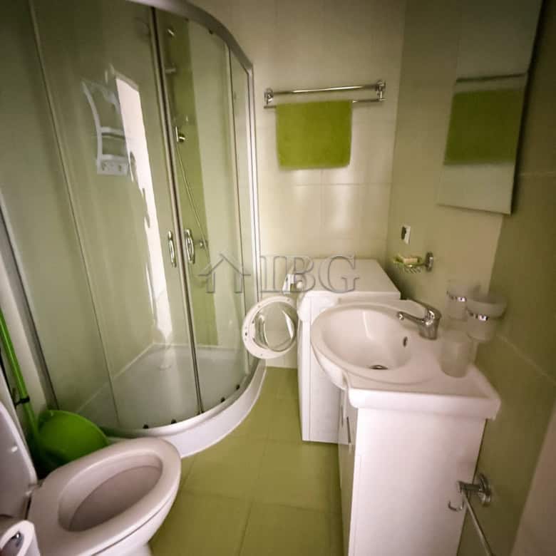 Furnished 2-room apartment bathroom with shower, toilet, and sink in a compact space.