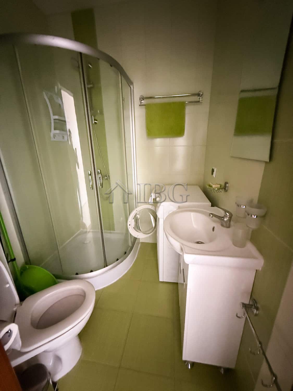 Furnished 2-room apartment bathroom with shower, toilet, and sink in a compact space.