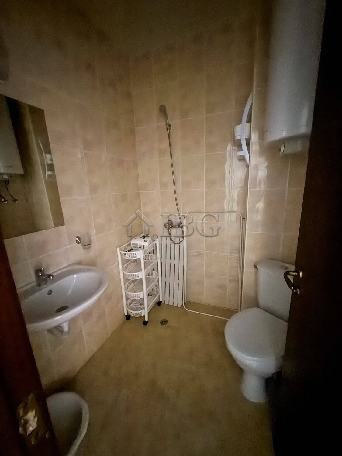 Furnished 2-room apartment bathroom with shower, toilet, and sink in a compact space.