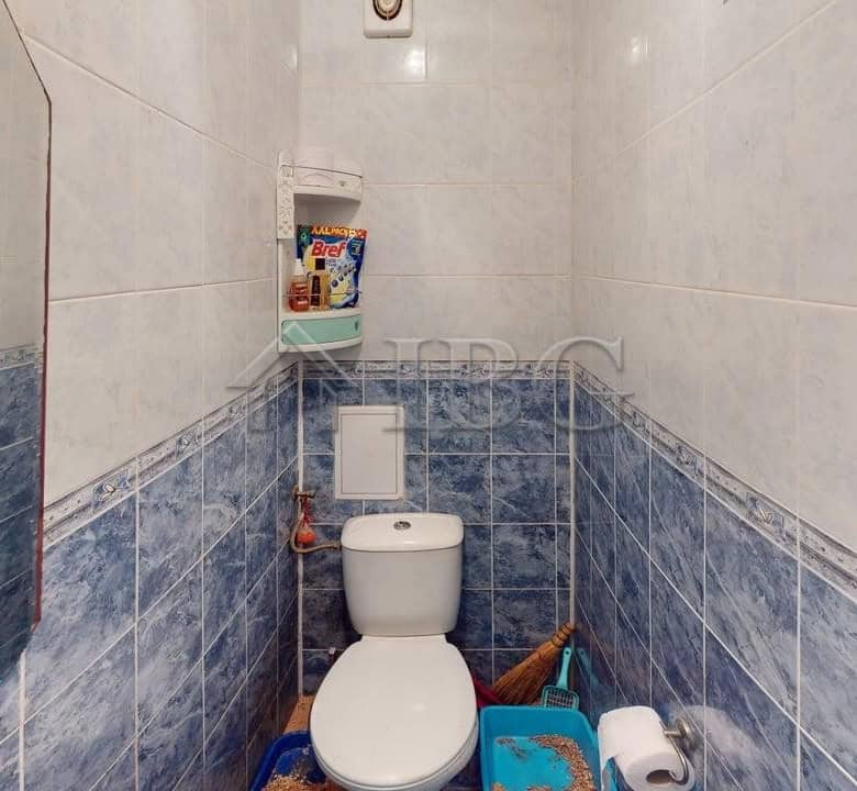 Small bathroom with toilet and cleaning tools in Kosharitsa apartment.