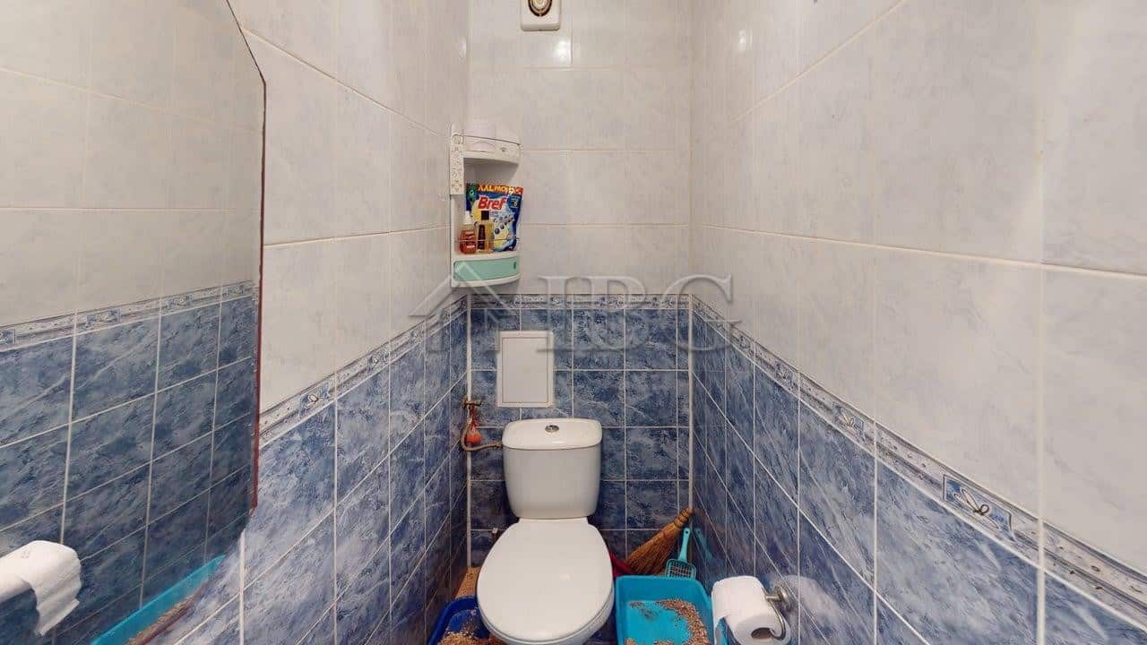 Small bathroom with toilet and cleaning tools in Kosharitsa apartment.