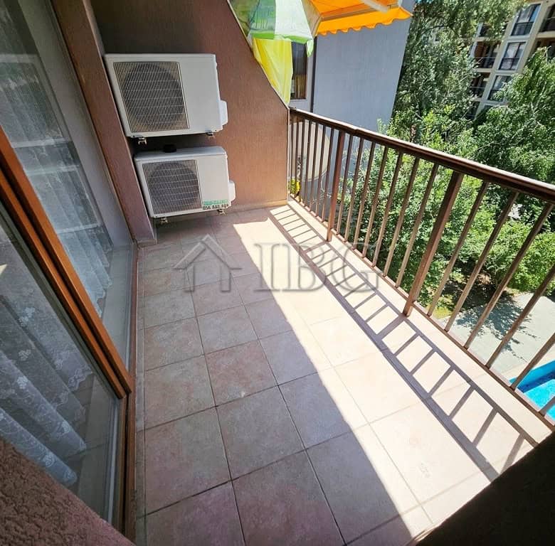 Balcony overlooking the pool and lush greenery in Sunny Beach, perfect for relaxing outdoors.