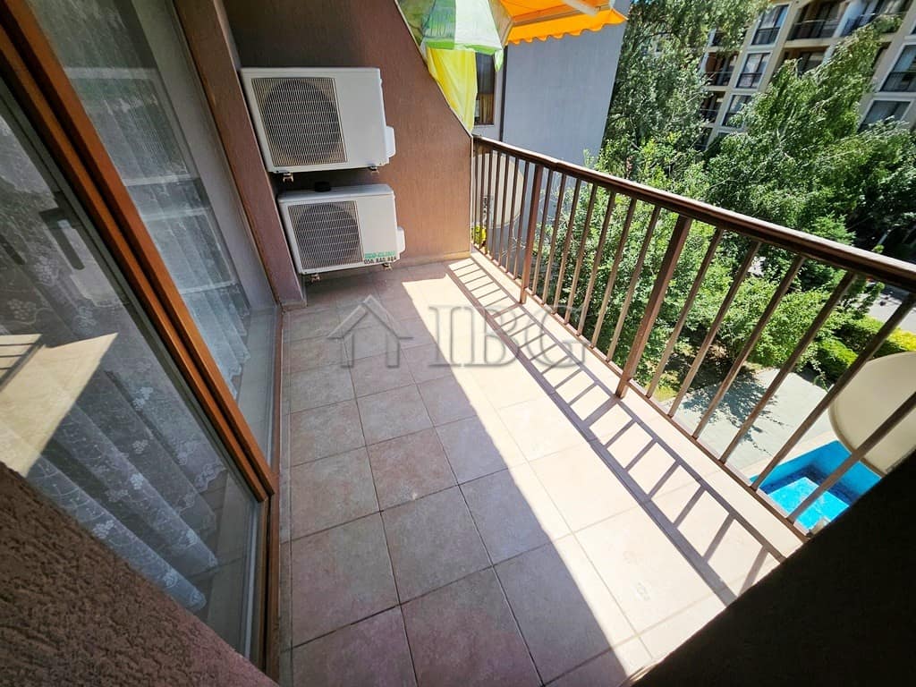 Balcony overlooking the pool and lush greenery in Sunny Beach, perfect for relaxing outdoors.