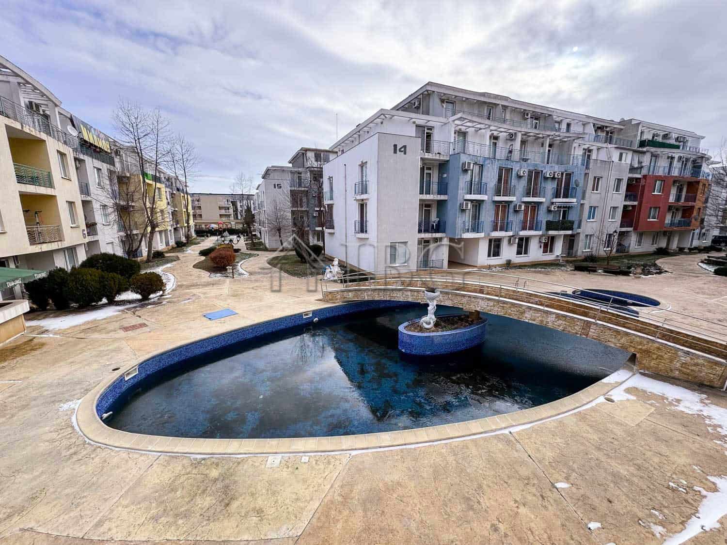 Charming studio apartment overlooking a serene pool on a sunny day at Sunny Beach.