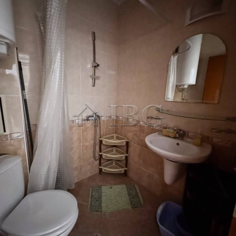 Bathroom of cozy studio with pool view and sunny beach backdrop.