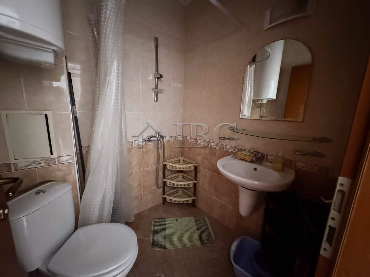 Bathroom of cozy studio with pool view and sunny beach backdrop.