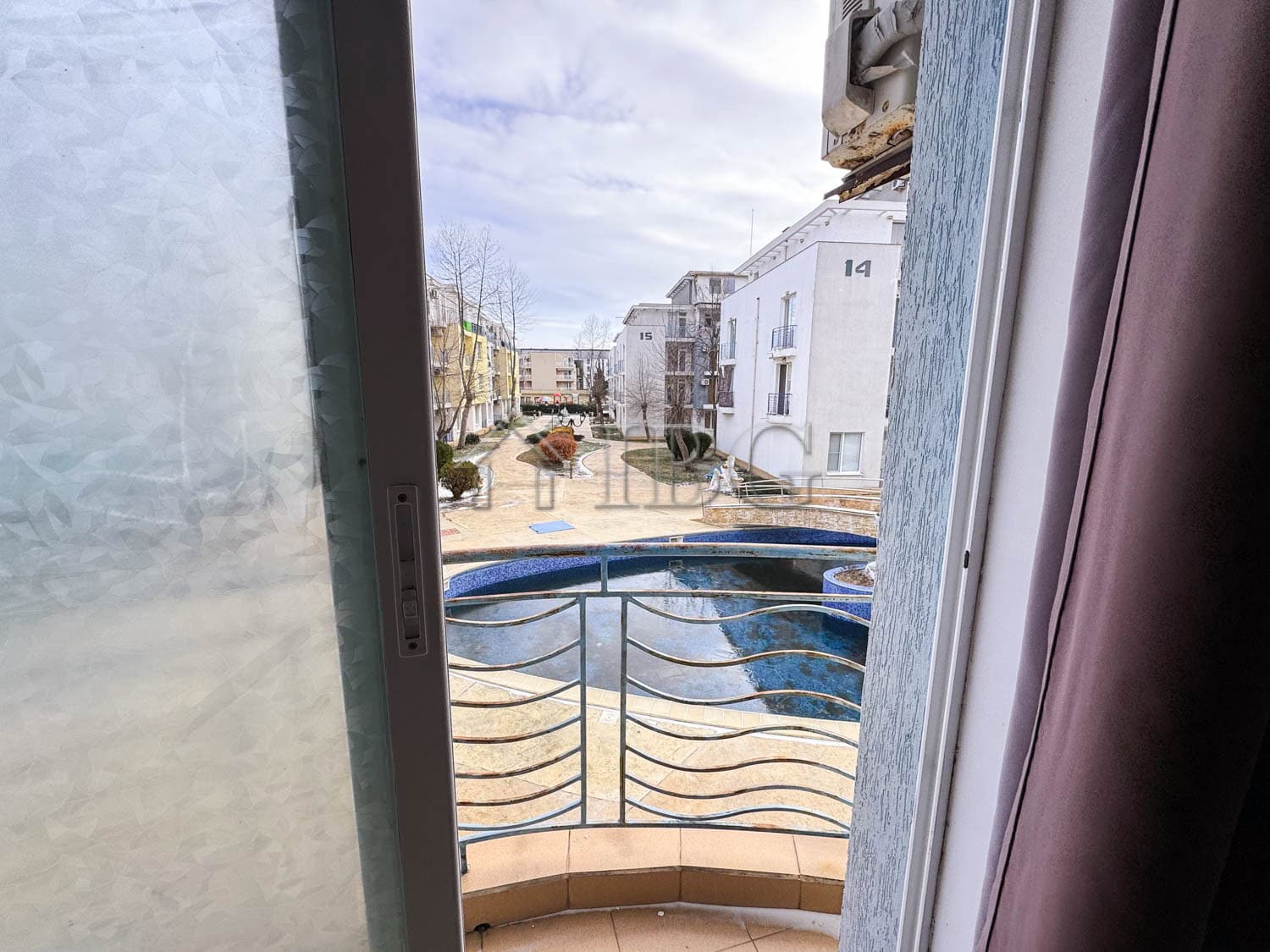 Cozy studio apartment overlooking a swimming pool on a sunny day at Sunny Beach.