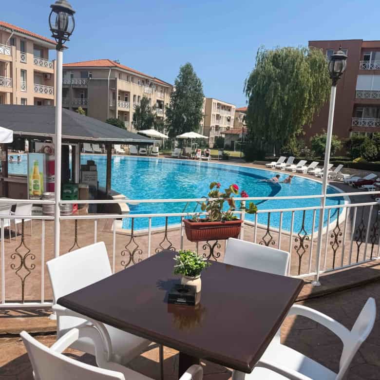 Poolside view of a sunny apartment complex in Sunny Beach, perfect for relaxing vacations.