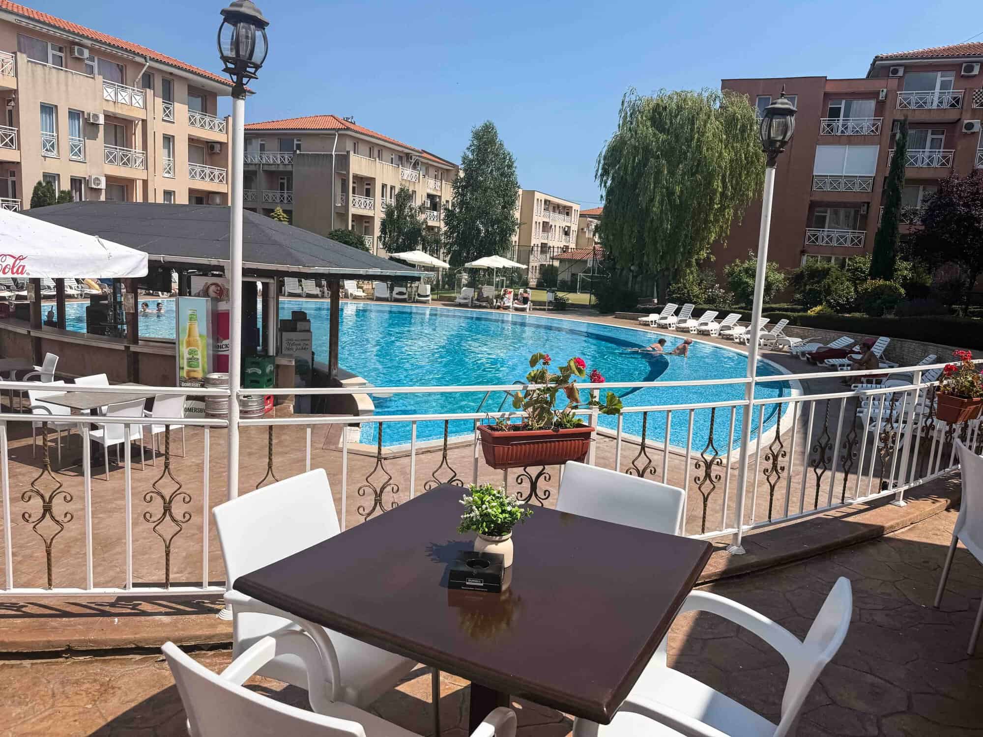 Poolside view of a sunny apartment complex in Sunny Beach, perfect for relaxing vacations.
