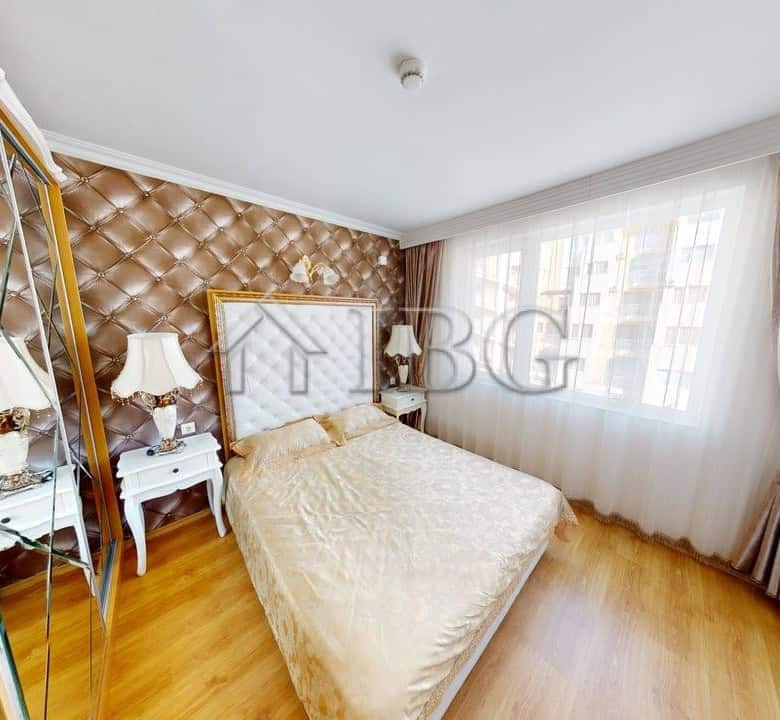 Interior view of a one-bedroom apartment with a large bed and elegant decor in Sunny Beach.