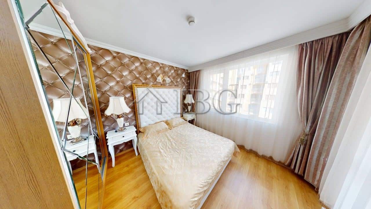 Interior view of a one-bedroom apartment with a large bed and elegant decor in Sunny Beach.
