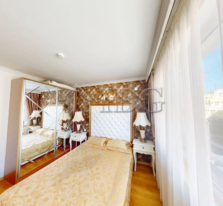 Bright bedroom with large window and sea view in Sunny Beach apartment.