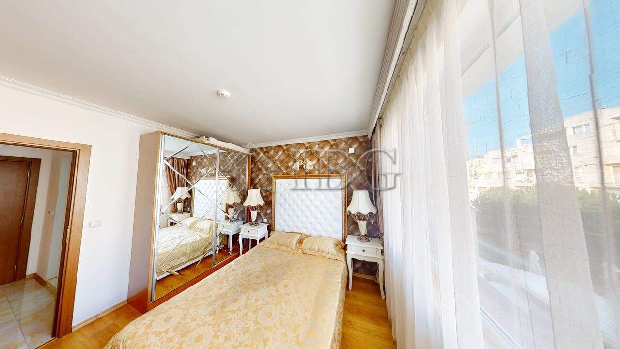 Bright bedroom with large window and sea view in Sunny Beach apartment.