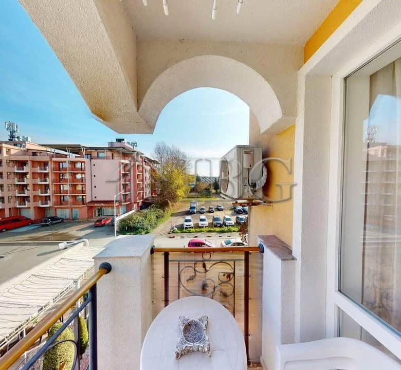 Cozy one-bedroom apartment with balcony overlooking Sunny Beach streets and nearby buildings.