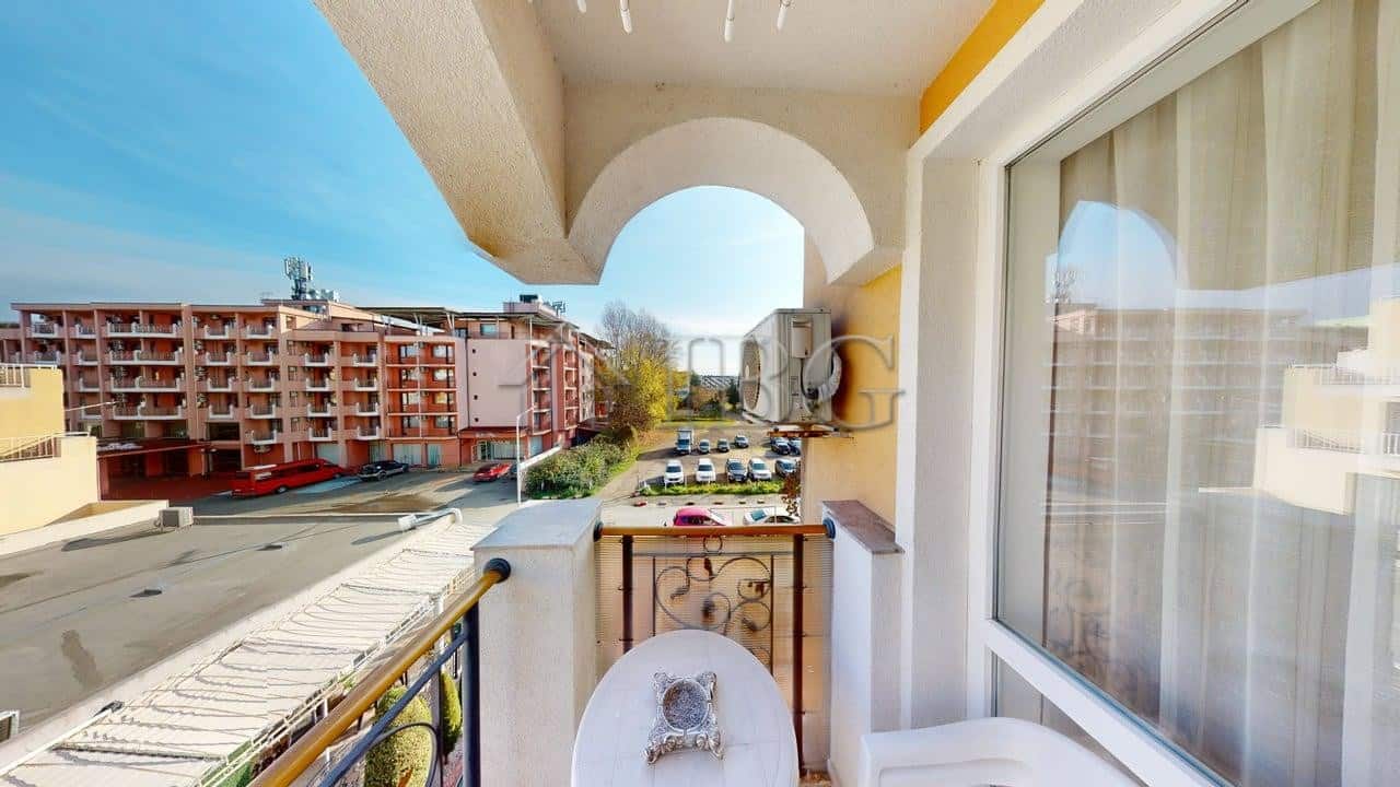 Cozy one-bedroom apartment with balcony overlooking Sunny Beach streets and nearby buildings.
