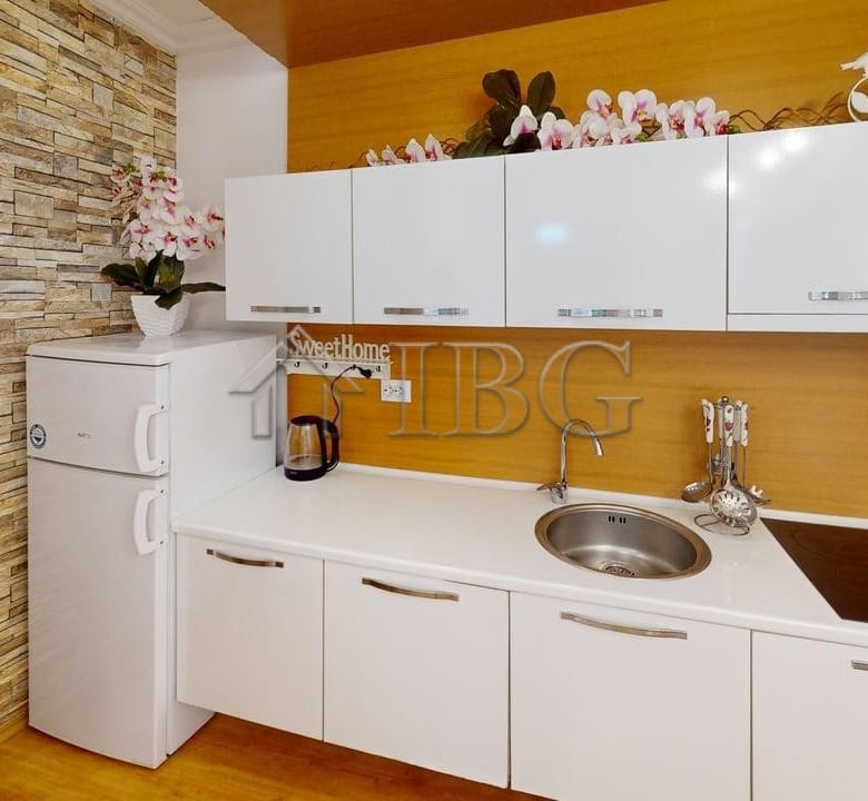 Modern one-bedroom apartment with stylish kitchen and decorative flowers in Sunny Beach.