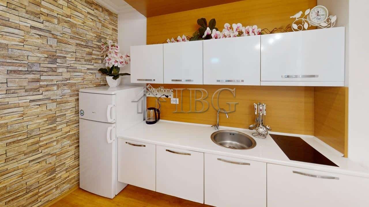 Modern one-bedroom apartment with stylish kitchen and decorative flowers in Sunny Beach.