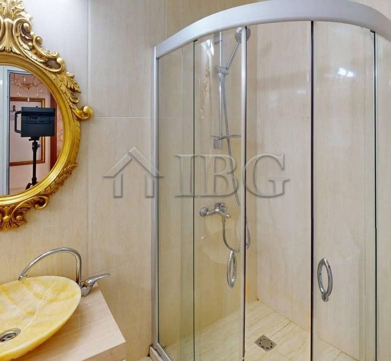 Bright bathroom with modern shower enclosure and elegant mirror.