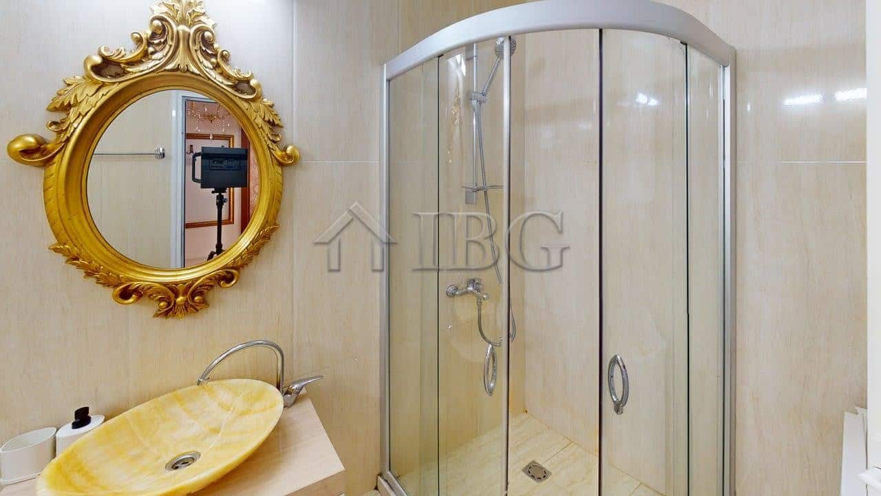 Bright bathroom with modern shower enclosure and elegant mirror.