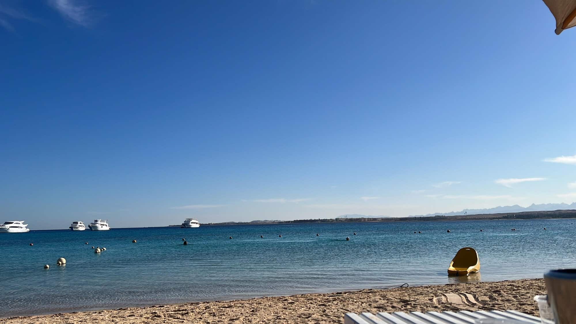 Beachfront property with stunning ocean views and boats in calm waters.
