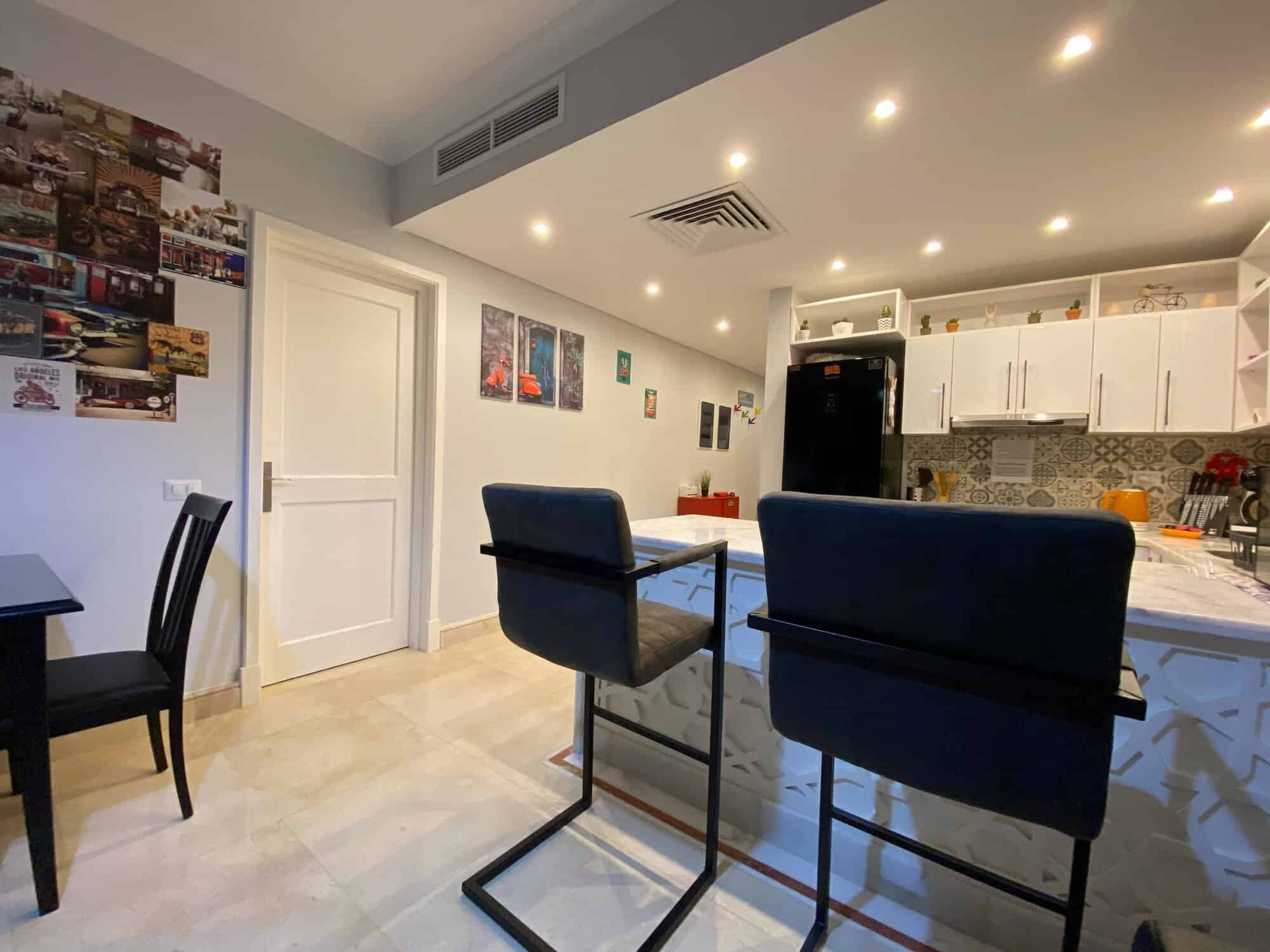 Modern kitchen and dining area with stylish furniture and decor.