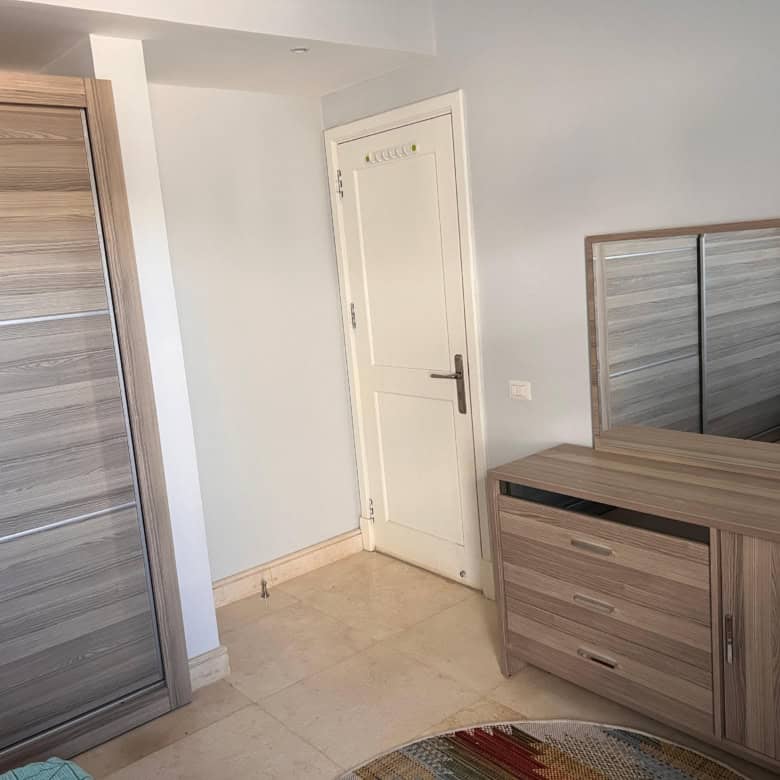 Spacious bedroom featuring a large wardrobe and matching dresser, ideal for comfortable living space.